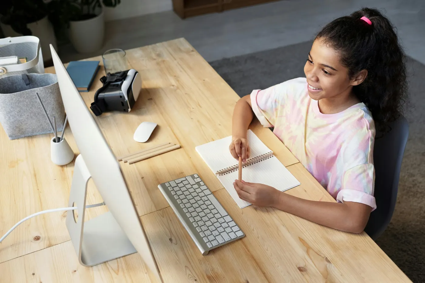 A girl at a desk with a computer, ready for an online session